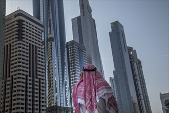 Pakistani man admiring highrise buildings in Dubai cityscape