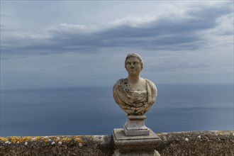 Carved bust on balcony over seascape