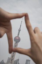 Chinese woman framing Shanghai tower