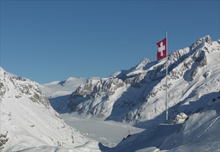 Flag over snowy slopes in remote mountains