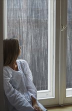 Caucasian woman looking out window
