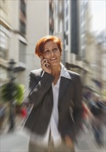 Caucasian businesswoman talking on cell phone in city