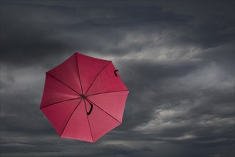 Red umbrella blowing in storm