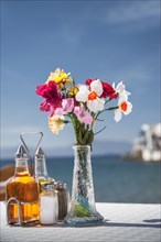 Seasonings and flowers on oceanfront cafe table