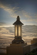 Ornate lantern on wall in desert