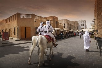 Men riding horses on Doha street