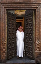 Smiling man opening ornate doors