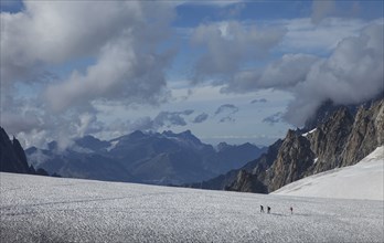 Hikers walking on glacier in remote landscape
