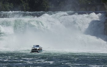 Boat floating near dramatic waterfall