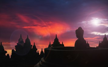 Silhouette of statue of Buddha at sunset