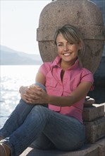 Smiling Caucasian woman sitting near lake