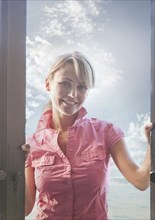 Portrait of smiling Caucasian woman standing in doorway