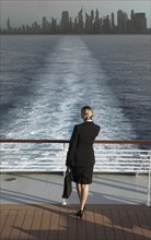 Caucasian businesswoman on boat leaving city