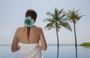 Caucasian woman admiring palm trees near ocean