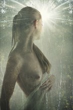 Double exposure of naked Caucasian woman in forest trees