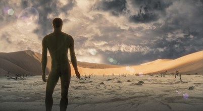 Naked man standing in desert