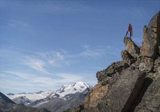 Distant Caucasian man standing on mountain rock