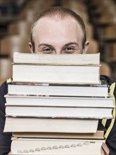 Caucasian student holding stack of books