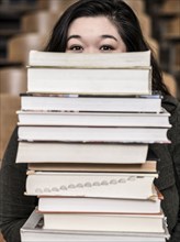 Korean student holding stack of books