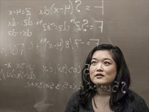 Korean student looking at formula on glass wall