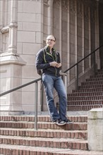 Caucasian student standing on campus staircase