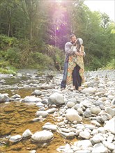 Couple hugging near stream