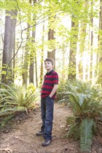 Caucasian boy standing on path in forest