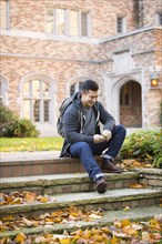 Mixed race college student sitting on campus steps