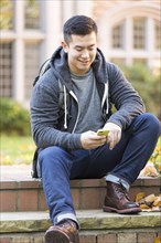 Mixed race college student sitting on campus steps