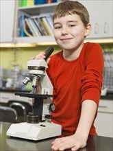 Caucasian boy using microscope in chemistry lab
