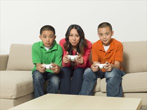 Mother and sons playing video games together