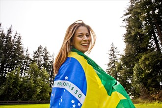 Hispanic woman wrapped in Brazilian flag