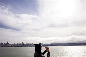 Woman taking picture of city skyline