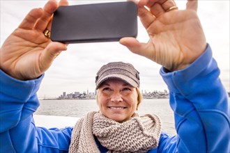 Woman taking picture by city skyline