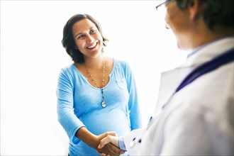 Pregnant woman shaking doctorÕs hand