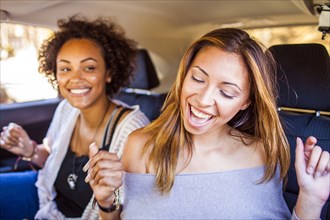 Women dancing together in car