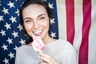 Caucasian woman eating ice cream near American flag