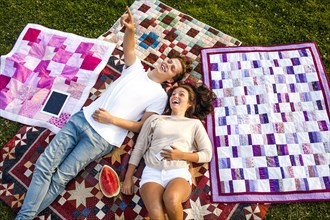 Caucasian couple relaxing on blankets in park