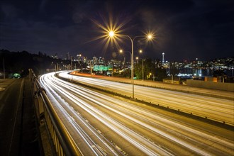 Long exposure of traffic on urban highway and city skyline at night