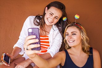 Caucasian teenage girls taking cell phone selfie