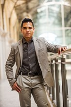 Hispanic businessman standing near banister