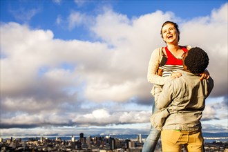 Couple laughing near scenic view of cityscape