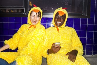 Couple wearing chicken costumes indoors