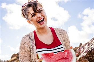 Caucasian woman eating watermelon outdoors