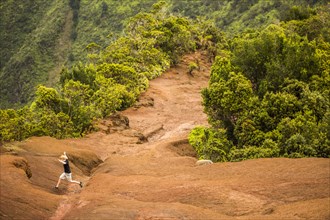 High angle view of man jumping on remote mountainside