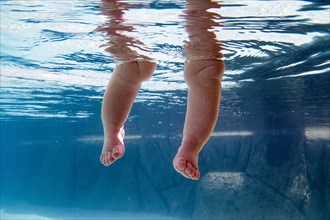 Close up of legs of baby submerged underwater