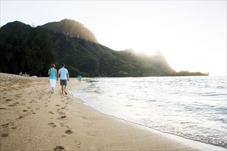 Couple walking together near ocean on beach