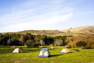 Camping tents in remote grassy field