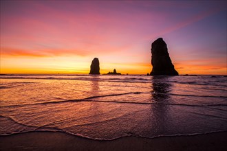 Silhouette of rock formations on Cannon Beach at sunset