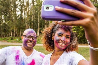 Couple taking selfie covered in pigment powder